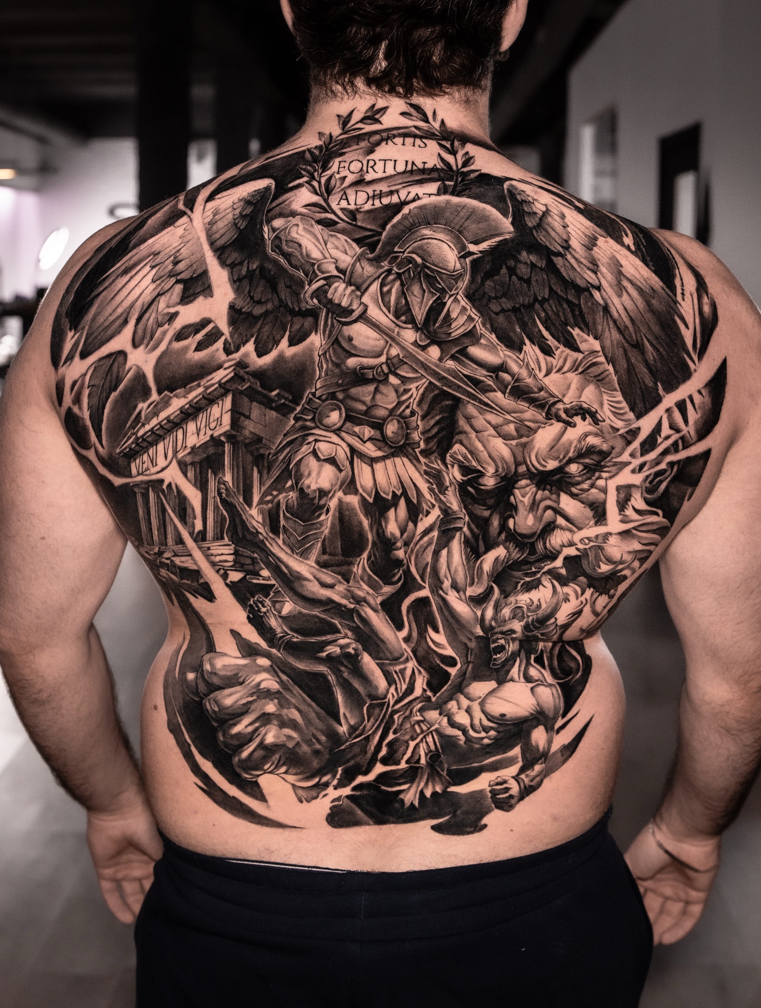 Back piece épico religioso con demonios — realismo black & grey